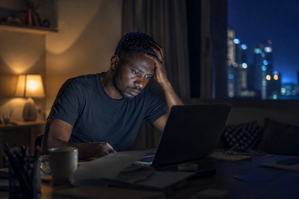 Une personne seule devant son ordinateur portable, tard le soir.